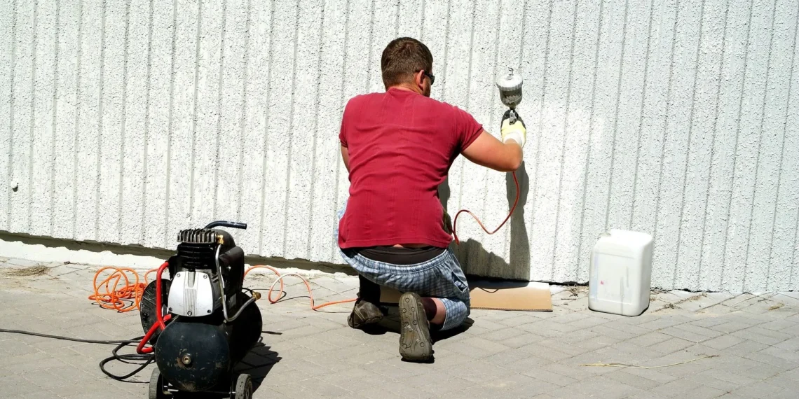 man using paint sprayer